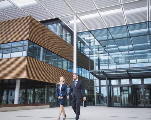 businessman-walking-with-colleague-outside-office-building_107420-74360